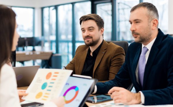 Business meeting in an office, workers discussing business affairs. Gadgets and papers on the table