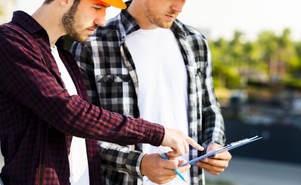 close-up-engineer-architect-looking-clipboard